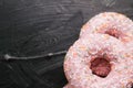 Frosted sprinkled donuts, sweet pastry dessert on rustic wooden background, doughnuts as tasty snack, top view food brand flat lay