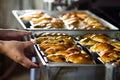 Bakery Chef pulling bread tray from oven Royalty Free Stock Photo