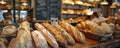 A bakery counter with various types of bread, including baguettes, sourdough, and ciabatta, with a Royalty Free Stock Photo