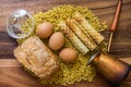 Bakery ingredients - bread, wafer rolls, pasta and eggs on wood table. Sweet pastry baking concept. copy space, top view.