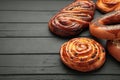 Bakery - various kinds of breadstuff. Bread rolls, bagel, sweet bun on black wooden background. Space for text