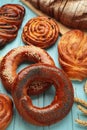 Bakery - various kinds of breadstuff. Bread rolls, bagel, sweet bun on blue background. Vertical photo