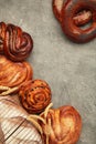 Bakery - various kinds of breadstuff. Bread rolls, bagel, sweet bun on grey background. Vertical photo