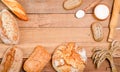 Bakery - various rustic crisp loaves of bread and rolls, wheat flour, a bunch of spikelets on wooden boards Royalty Free Stock Photo
