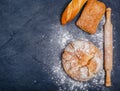 Bakery - various rustic crispy buns with bread, wheat flour, rolling pin on a black background