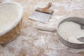 Bakery workbench with spatula, flour basket, sieve and formatted bread