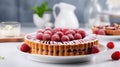 Bakewell tart with frangipane filling and raspberry jam on blurred white kitchen background