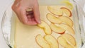 Baking Apple pie. Biscuit batter and sliced apples in a baking glass form. Royalty Free Stock Photo