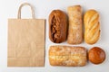 Baking background with eco disposable paper bag from a supermarket recyclable and whole fresh baked loaves of bread top Royalty Free Stock Photo