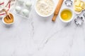 Baking background with flour, eggs, kitchen tools, utensils and cookie molds on white marble table. Top view. Flat lay style. Mock