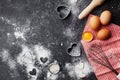 Baking background with flour, rolling pin, eggs, and heart shape on dark kitchen table top view for Valentines day cooking. Flat l Royalty Free Stock Photo