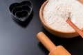 Baking background with flour, rolling pin and heart shape on a dark table with copy space, top view, flat lay Royalty Free Stock Photo