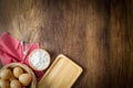 Baking background. Flour in wooden cup, eggs in wicker basket, Egg beater on red placemat and Bread cutting board on wooden panel Royalty Free Stock Photo