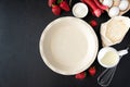 Baking background. Food ingredients for baking: flour, eggs, sugar, milk, berries and empty baking dish on dark background. Flat Royalty Free Stock Photo