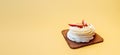 Baking banner. Pastry white souffle with cream and fresh strawberries on a soft yellow background