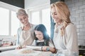 Baking, bonding and child with mother and grandmother in the kitchen learning to bake in their house. Food, love and