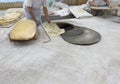 Baking the bread in tandoor. Woman rolls out dough. Making traditional flat cakes. Making bread in traditional bakery shop Royalty Free Stock Photo