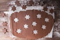 Baking Christmas cookies. Roll out the dough to cut out stars on a wooden background.