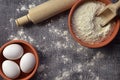 Flour, eggs and rolling pin on a wooden background. Top view. Or Royalty Free Stock Photo