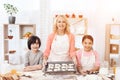 Baking cookies. Beautiful grandmother with her grandchildren bake cookies in kitchen. Royalty Free Stock Photo