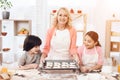 Baking cookies. Beautiful grandmother with her grandchildren bake cookies in kitchen. Royalty Free Stock Photo
