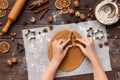 Woman cutting gingerbread with metal fir tree cutter