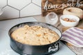 Baking dish with baked apple pie stands on kitchen counter next to ingredients and wooden sign Home sweet home Royalty Free Stock Photo