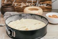 Baking dish with raw apple pie dough stands on kitchen counter next to ingredients and wooden sign Home sweet home Royalty Free Stock Photo