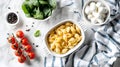 Baking dish of raw conchiglie pasta with cheese, tomatoes and spinach on light background Royalty Free Stock Photo