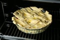 Baking dish with raw homemade apple pie in oven, closeup Royalty Free Stock Photo