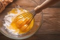 Baking essentials Eggs whisked in a bowl on rustic table Royalty Free Stock Photo