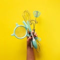 Baking flat lay. Female hands holding kitchen tools, sieve, rolling pin, spatula and bruch on yellow background. Banner with copy