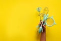 Baking flat lay. Female hands holding kitchen tools, sieve, rolling pin, spatula and bruch on yellow background. Banner with copy