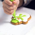 Baking holiday cookies. Child hands decorating gingerbread in the form of a a snowman with icing sugar using a pipping bag. Christ Royalty Free Stock Photo