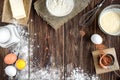 Baking ingredients for cooking chocolate cupcakes or cake. Bowl with sugar, eggs, flour, butter on dark wooden background. Royalty Free Stock Photo