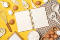 Baking ingredients, cooking utensil and open notebook on yellow background. Template for cooking recipes or your design Royalty Free Stock Photo
