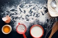 Baking ingredients on a dark, stone table: eggs, flour and milk