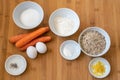 Baking ingredients for an Easter carrot cake on a wooden kitchen board, high angle view from above Royalty Free Stock Photo