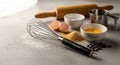 Baking ingredients and tools including whisk, eggs, flour, sugar, and chocolate chips on a light counter Royalty Free Stock Photo