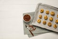 Baking pan with unbaked cookies and chocolate chips on white wooden table, flat lay. Space for text Royalty Free Stock Photo