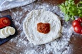 Baking pizza rolled out dough blob of tomato sauce