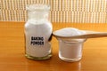 Baking powder in a bottle glass jar and wooden spoon