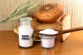 Baking powder in a glass jar and wooden spoon with cookie and bread Royalty Free Stock Photo