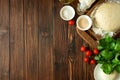 Baking in rural kitchen. Dough and ingredients for baking pizza on vintage brown wooden table. Top view. Rustic background Royalty Free Stock Photo