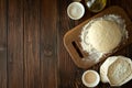 Baking in rural kitchen. Dough and recipe ingredients on vintage brown wooden table. Top view. Rustic background Royalty Free Stock Photo