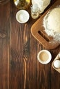 Baking in rural kitchen. Dough and recipe ingredients on vintage brown wooden table. Top view. Rustic background Royalty Free Stock Photo