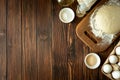 Baking in rural kitchen. Dough and recipe ingredients on vintage brown wooden table. Top view. Rustic background Royalty Free Stock Photo