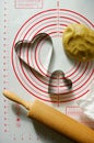 Baking scenery with heart shaped cookie cutter, rolling pin for dough, silicone baking mat. Romantic food, photo for recipe book
