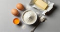 A baking setup on a gray surface includes two whole brown eggs, an open half egg with yolk visible, Royalty Free Stock Photo