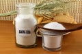 Baking soda in a bottle glass jar and wooden spoon with cookie and bread Royalty Free Stock Photo